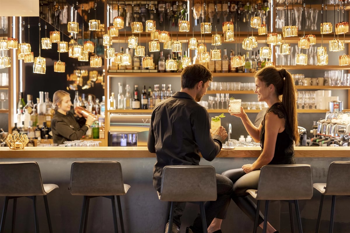 Ein Pärchen genießt einen Cocktail an der Bar im Hotel Edelweiss Wagrain